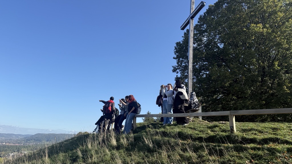Schüler stehen am Gipfelkreuz und genießen den Ausblick