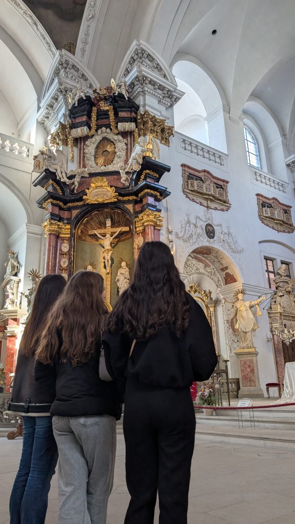 3 Schülerinnen bestaunen die schöne Kirche mit goldenen Details